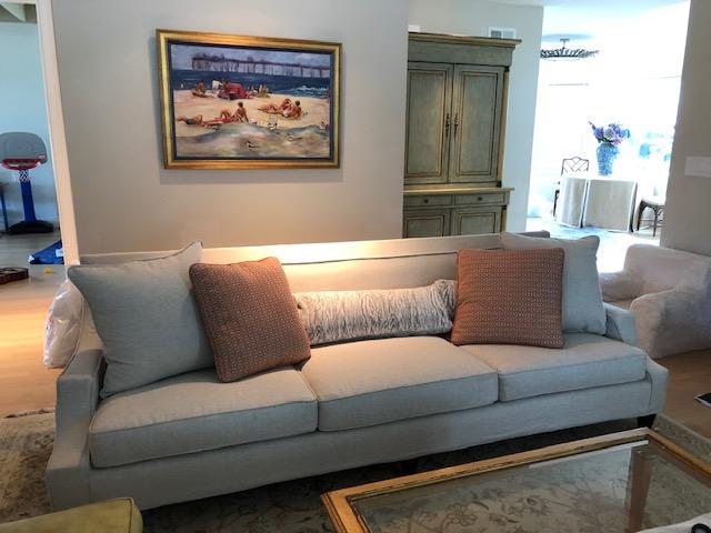 Contemporary style 3 seater sofa slipcovered to allow legs showing.