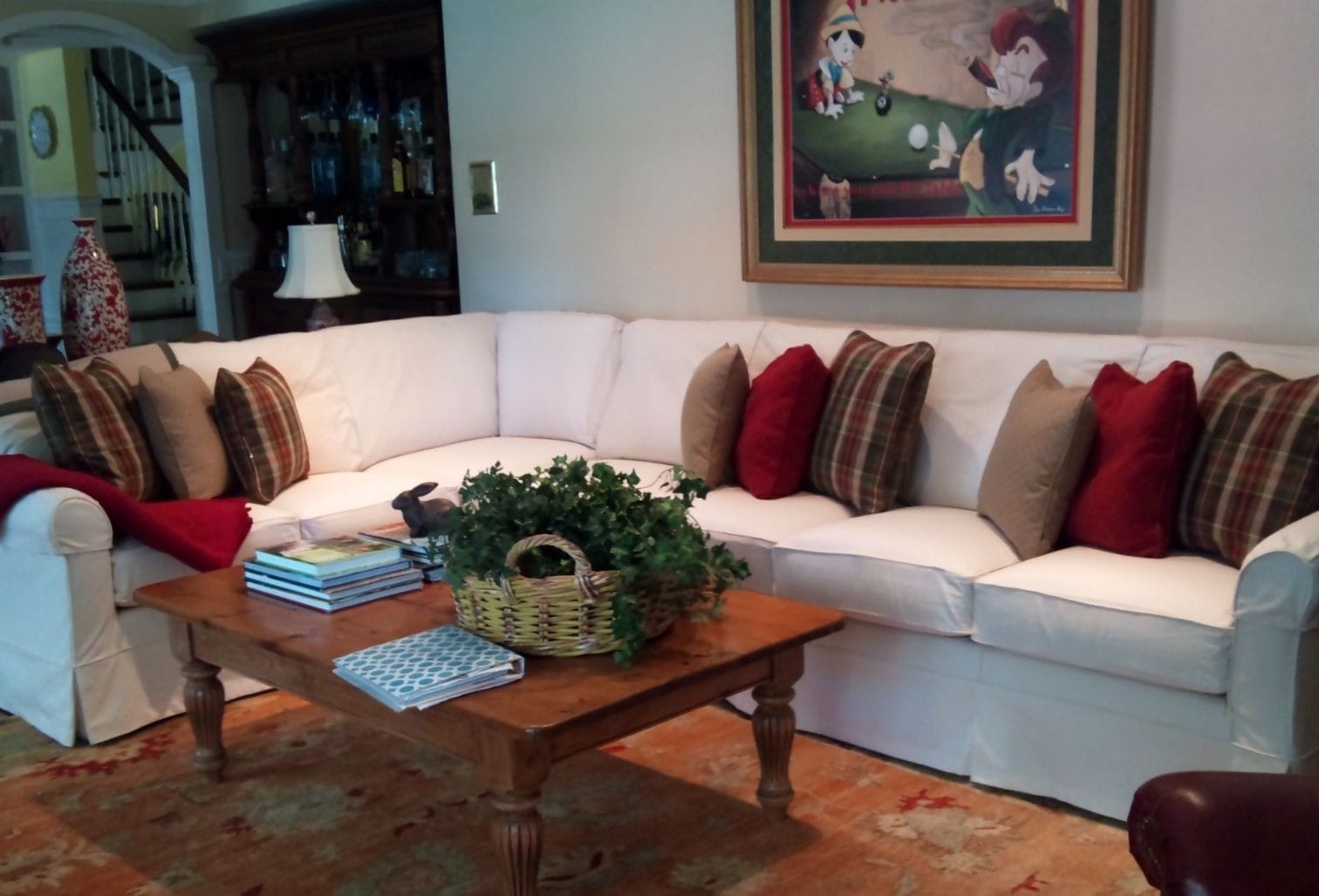 6 seater sectional sofa slipcovered with pleated skirt that goes to the floor.  Shown with decorative pillows in contrasting colors.
